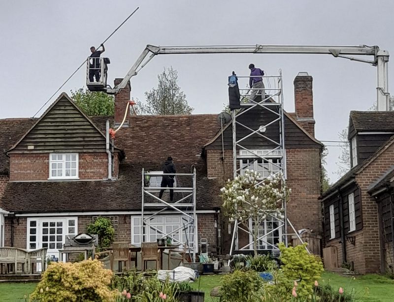 The Moss Cleaners using cherry picker and scaffolding to clean roof safely and professionally in Frimley, Surrey